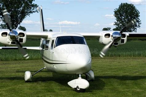 A White Twin-engine Plane Standing on a Grassy Airfield Stock Photo - Image of people, runway ...