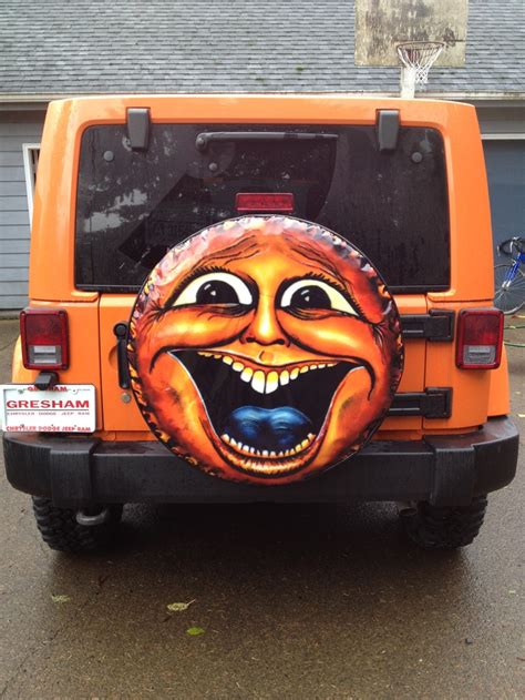 An Orange Jeep With A Face Painted On It