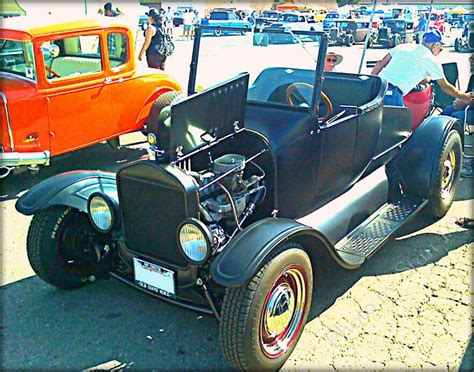 An Old Model T Car Parked In A Parking Lot Next To Other Antique Cars