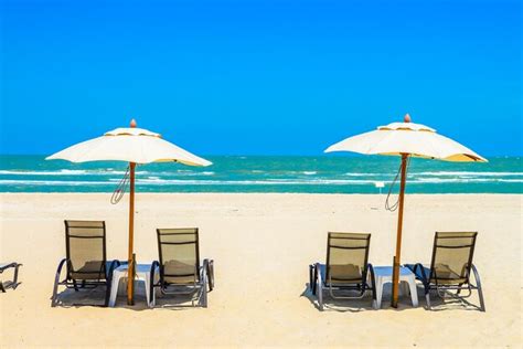 Premium Photo Deck Chairs On Beach Against Clear Blue Sky