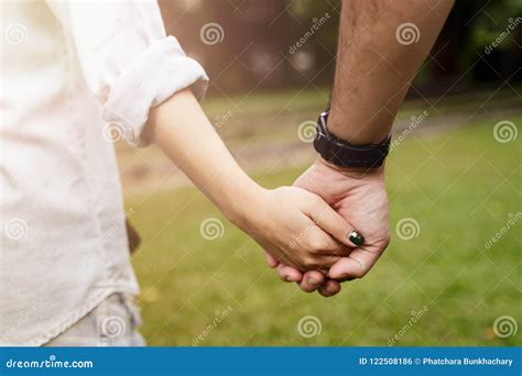 Happy Romantic Couple In Love Holding Hands And Walking In Park Stock