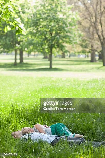 Couple Cuddling Laying Park Photos And Premium High Res Pictures Getty Images