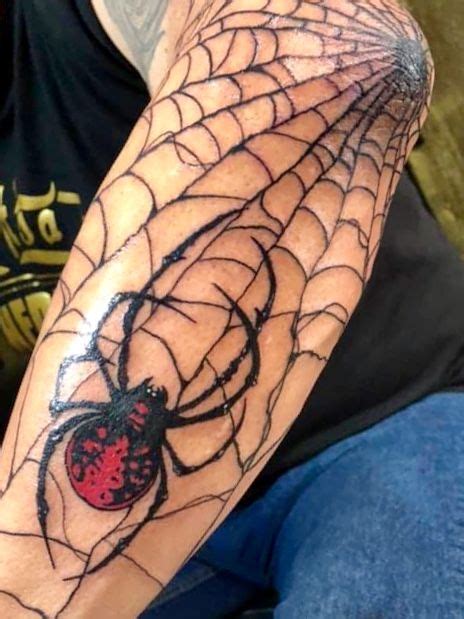 A Spider Web Tattoo On The Arm With A Ladybug In It S Center