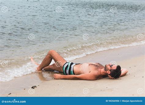 Hombre Joven Que Miente En La Playa Foto De Archivo Imagen De Verano