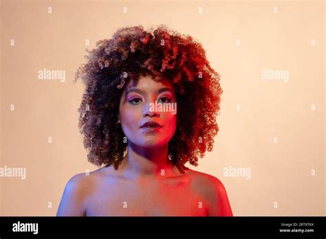 Biracial Woman With Curly Hair Wearing Pink Eyeshadow And Lipstick In