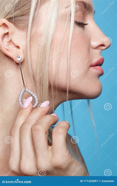 Female Touches The Earring In The Ear With Her Fingers Stock Image