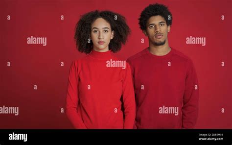 Sad African American Millennial Guy And Woman In Red Sweaters Looking