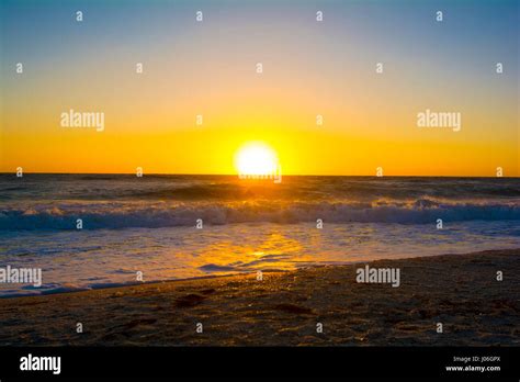 sunset over ocean beach Stock Photo - Alamy