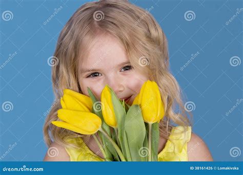 Menina Que Sorri E Que Guarda Um Ramalhete Das Flores Foto De Stock