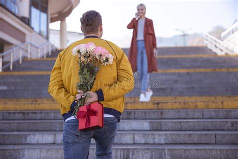 Man Die Zijn Vriendin Een Bouquet Geeft Stock Afbeelding Image Of Blij Samen 164559203