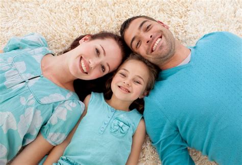 Sonriendo Los Padres Y La Ni A En El Piso Con Las Cabezas Juntas Foto