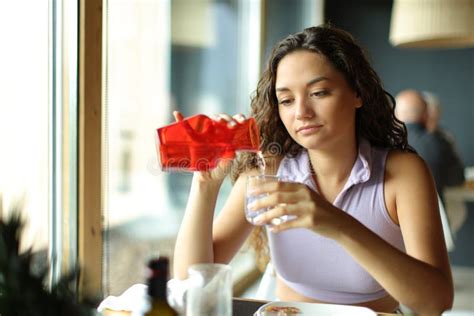 Woman Filling Glass of Water from Bottle in a Restaurant Stock Photo ...