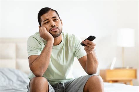 Man with Bored Expression Holding Remote Stock Image - Image of ...