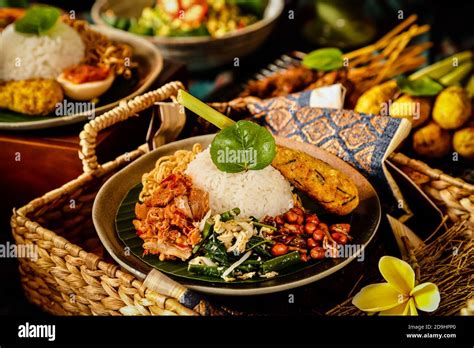 Nasi Campur Bali. Balinese meal of rice with shredded chicken, vegetable salad, peanuts, satay ...