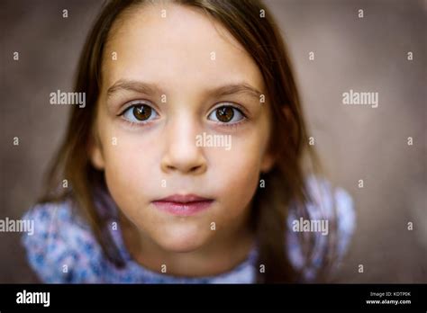 Portrait Of Little Girl Looking Up At The Parent Outdoors A Child Is