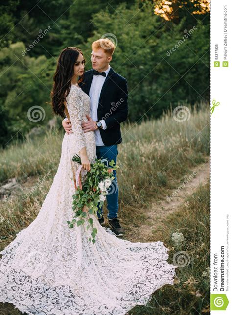 Recienes Casados Felices Que Se Colocan Y Que Abrazan Imagen De Archivo