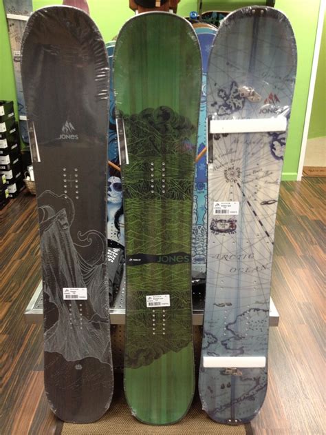 Three Snowboards Are Stacked On Top Of Each Other In Front Of A Store