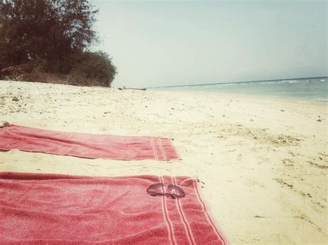 Premium Photo Sunglasses On Red Blankets At Beach Against Clear Sky