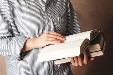 Premium Photo Woman Holding Books Against Brown Background Close Up