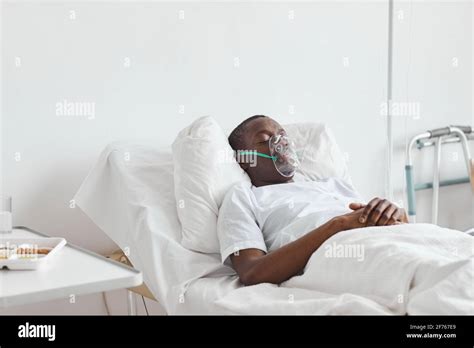 Portrait Of African American Man Sleeping On Hospital Bed With Oxygen