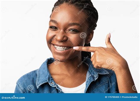 African Girl In Braces Pointing Finger At Smile White Background Stock