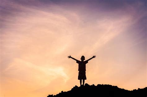 Premium Photo Silhouette Boy With Arms Raised Standing Against Sky