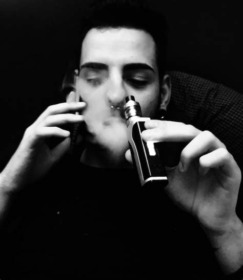 Premium Photo Close Up Of Young Man Smoking Cigarette Against Black