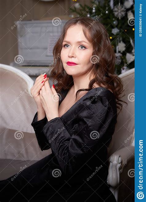 An Attractive Happy Young Brunette Woman In An Elegant Black Dress In