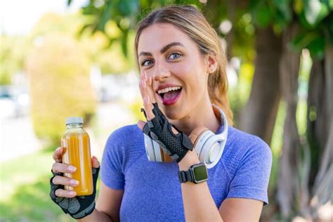 Mulher Jovem E Bonita Segurando Um Suco De Laranja Ao Ar Livre