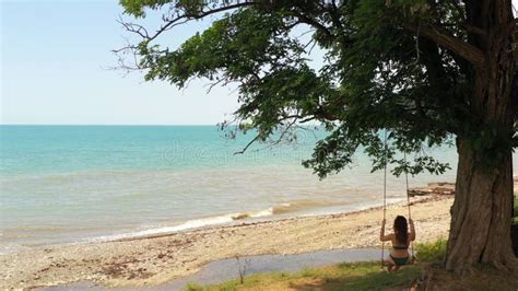 Sea And Deserted Sandy Beach Slender Girl In Bikini Swinging On Rope Swing Stock Video Video