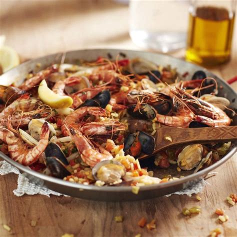 A Pan Filled With Seafood And Mussels On Top Of A Wooden Table