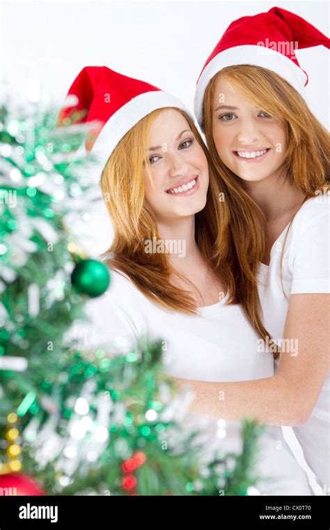 happy young friends behind Christmas tree Stock Photo - Alamy