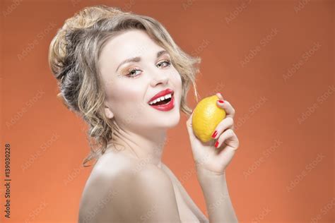 Sexy Fruit Series Smiling Happy Naked Caucasian Blond Girl With Lemon Fruit Against Orange