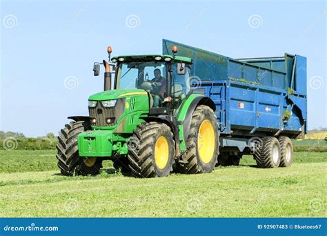 John Deere Green Tractor Pulling A Trailer In Grass Field Editorial