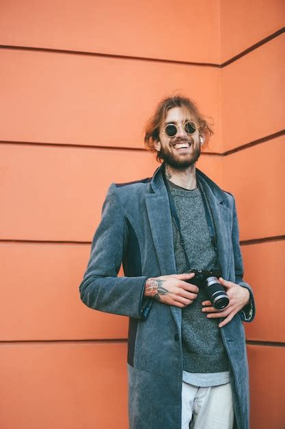 Retrato de un hombre barbudo sonriente con cámara vintage Foto Gratis