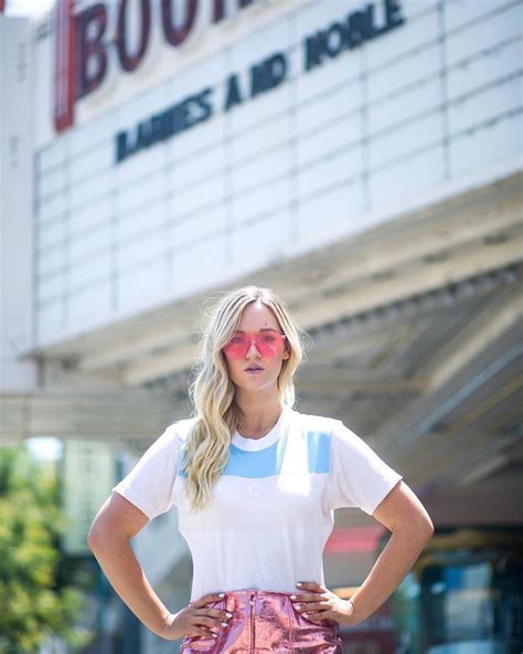 A Woman Standing In Front Of A Movie Theater With Her Hands On Her Hips