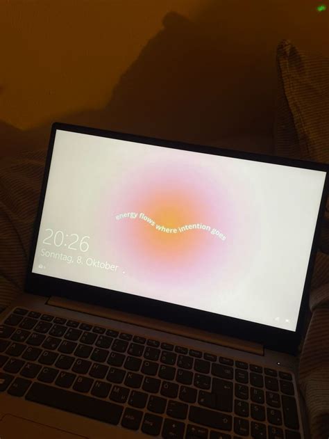 An Open Laptop Computer Sitting On Top Of A Bed Next To A Person S Feet