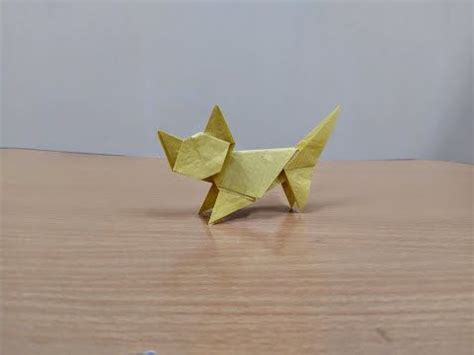 an origami cat sitting on top of a wooden table