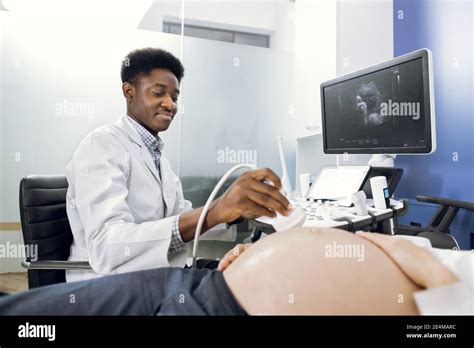 Close Up Of African Man Doctor Sonographer Scanning Young Pregnant