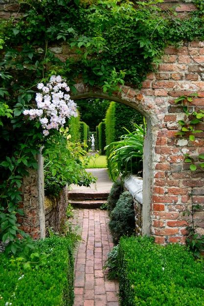 Premium Photo | An arch in a brick wall in a garden