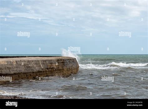 Wave Splashing Over The World Famous Cobb At Lyme Regis Dorset England