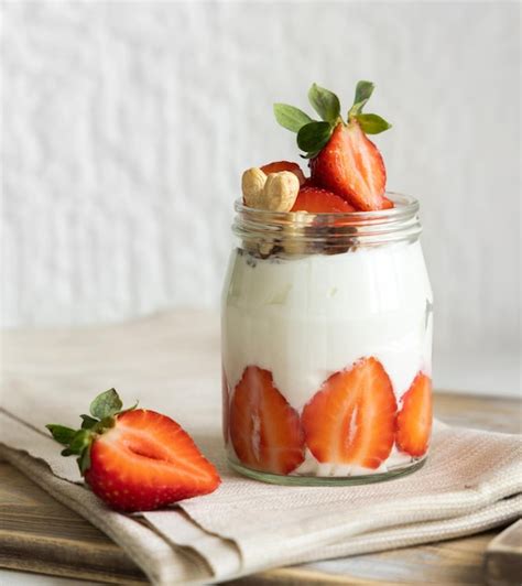 Nueces De Yogur Griego Y Fresas En Un Frasco De Vidrio En Una Bandeja