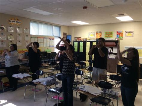 A Group Of People Standing In A Classroom