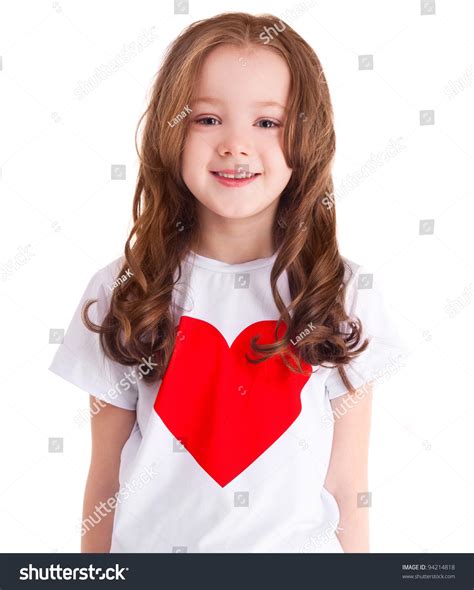 Happy Smiling Six Year Old Girl Wearing A Shirt With A Big Red Heart Isolated Against White