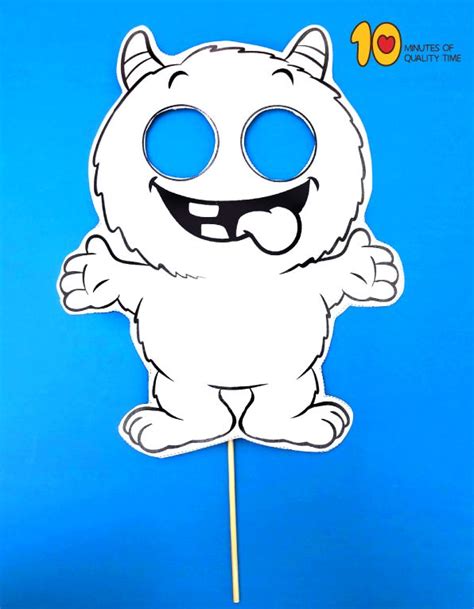 A Paper Cut Out Of A White Cat With Blue Eyes On A Stick In Front Of A