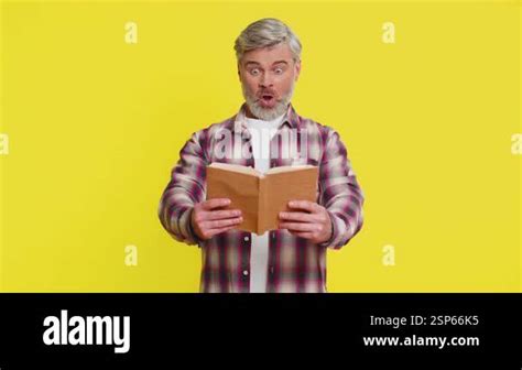 Mature Man Opens Book With Eager Hope Showing Bright Surprise And Stunned Excitement Middle