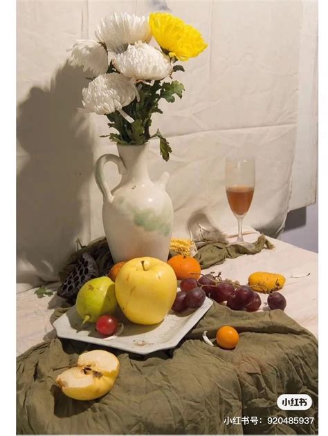 A White Vase Filled With Flowers Sitting On Top Of A Table Next To