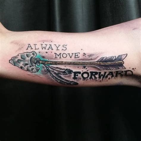 Big colored ancient tribal arrow tattoo on biceps with "Always move forward" lettering ...