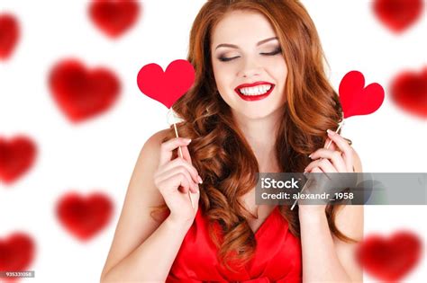 Beautiful Redhaired Woman With Red Heart In Hands On A White Background