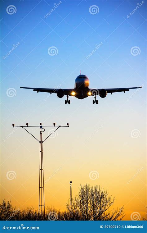 Het Vliegtuig Landt Bij Zonsondergang Stock Foto Image Of Donker